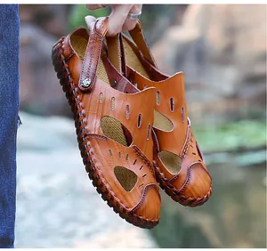 Primer plano de sandalias de cuero marrón para hombre con costuras manuales, chic.