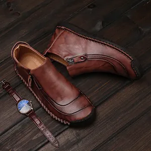 Detail van bruine herenleren laarzen met handgemaakte stiksels en rits aan de zijkant