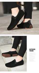 Gros plan de mocassins noirs en daim pour hommes avec semelles à picots orange