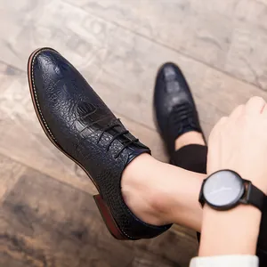 Λεπτομέρεια από μπλε navy ανδρικά παπούτσια oxford με σχέδιο κροκόδειλου φορεμένα με ρολόι