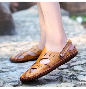 Primer plano de sandalias de cuero marrón para hombre hechas a mano con diseño calado.