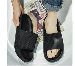 Close-up detail of black thick-soled slide sandals showing upper texture and fit