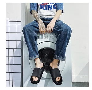 Model wearing black thick-soled slide sandals sitting on a white washing machine