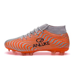 Detalle de bota de fútbol alta con patrón de ondas naranjas y tacos AG para césped