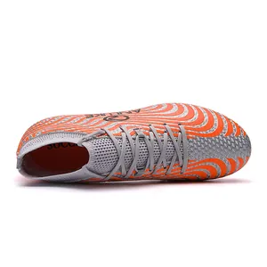 Detalle superior de botas de fútbol de caña alta con patrón de ondas naranja vibrante.