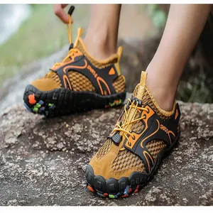 Primo piano di scarpe da scoglio traspiranti su terreno roccioso all'aperto.