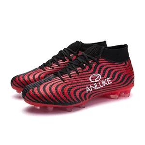 Vista detallada del patrón ondulado rojo y negro en botas de fútbol con tacos AG