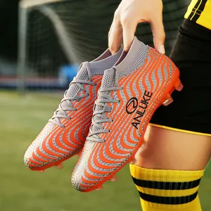 Botas de fútbol de caña alta profesionales con un patrón de ondas en naranja y gris