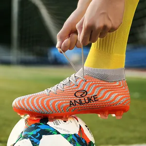 Vista detallada de botas de fútbol de caña alta con patrón de ondas naranjas y tacos AG