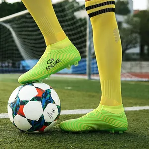 Primer plano detallado de botas de fútbol de caña alta verde lima en césped artificial.