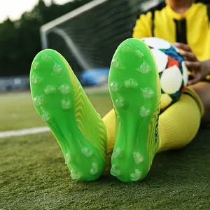 Vista detallada de suelas de botas de fútbol verdes con tacos AG duraderos para césped