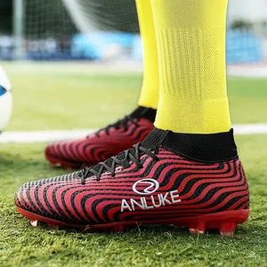 Botas de fútbol de caña alta rojas y negras de alto rendimiento con tacos AG en césped