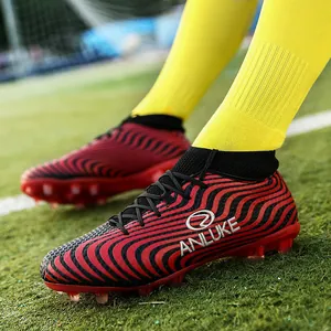 Vista detallada del patrón ondulado rojo y negro de las botas de fútbol altas con tacos AG