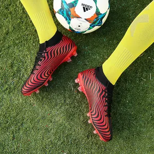 Botas de fútbol de caña alta con tacos AG mostradas sobre césped artificial detalle