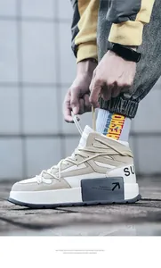 Primo piano di sneaker alte da uomo con suola spessa nei colori beige e bianco