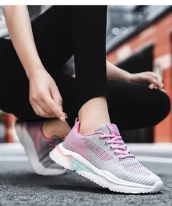 Primo piano di sneakers in mesh traspirante rosa e grigio indossate in un contesto urbano