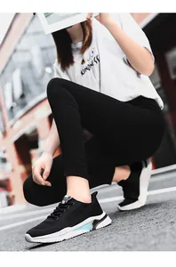 Scarpe da corsa traspiranti in maglia da donna in bianco e nero indossate ai piedi