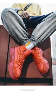 Vista dettagliata di eleganti sneakers high-top arancioni con zeppa da uomo in città
