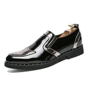 Detail of black patent leather brogue shoe with silver studs and wingtip design