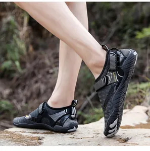 Dettaglio di scarpe da acqua a cinque dita traspiranti su rocce per escursionismo