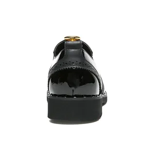 Close-up back view of black Brogue dress shoes with gold hardware and studded soles