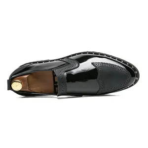 Professional detail showing the rivet trim and patent leather on black brogue shoes.