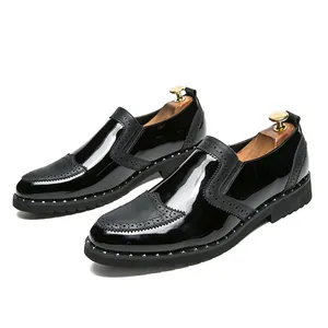 Macro detail of black patent leather brogue shoes featuring silver-tone rivets on the sole