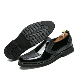 Detailed view of black patent leather brogue shoes with silver studs and non-slip sole