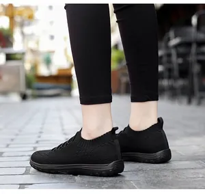 Macro view of black breathable mesh slip-on sneakers for women walking on outdoor street