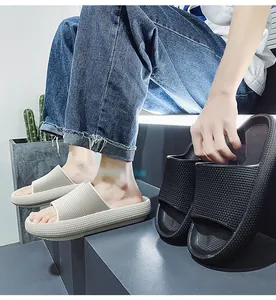 Detailed view of lightweight thick-soled slides in beige and black for home use.