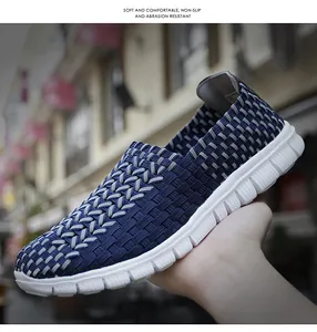 Baskets à enfiler tissées et respirantes bleues et grises tenues par une main humaine