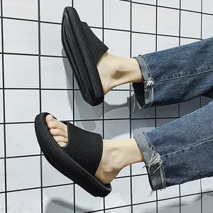 Men's black platform slide sandals with textured mesh strap on grid background.