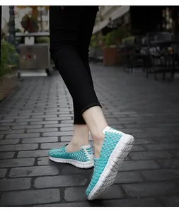 Gros plan de chaussures tissées turquoise avec semelle en caoutchouc blanc sur la rue