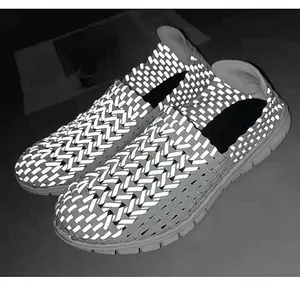 Détail de chaussures tissées réfléchissantes avec bandes fluorescentes haute visibilité.