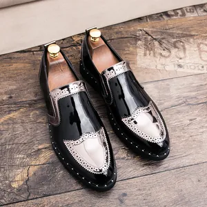 Detailed view of men's black patent leather brogue shoes with silver accents and studs