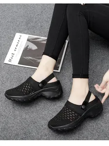 Vista detallada de zapatos de plataforma de malla negra transpirable para mujer en modelo