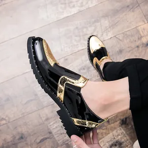 Detailed macro view of men's black patent leather shoes featuring gold metallic brogue accents.