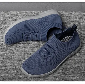 Macro shot of breathable blue fly-knit mesh slip-on sneakers with elastic collar details