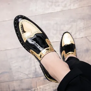 Detail view of men's black patent leather brogues with gold accents and rivet studs
