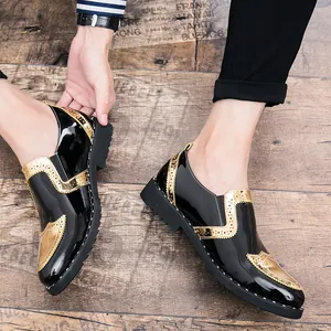 Close-up of stylish black and gold Brogue shoes for men with patent leather finish