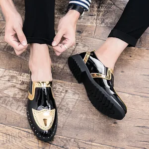 Close-up detail of black patent leather brogue shoes featuring gold metallic rivets and textured soles