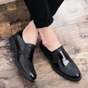 Close-up detail of stylish black patent leather Brogue shoes with silver rivet studs