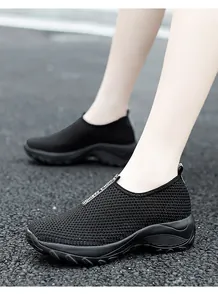 Detailansicht atmungsaktive schwarze Damen-Sneaker mit dicken Plateausohlen und Keilabsatz.