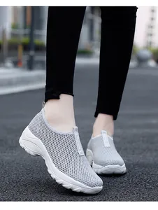 Detailansicht von grauen atmungsaktiven Flyknit-Sneakern mit dicker Plateausohle.