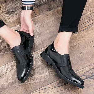 Close-up of men's black patent leather Brogue shoes with stylish wingtip carving details