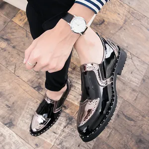 Detail view of men's patent leather brogue shoes with rivet accents and metallic trim