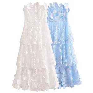 Detailed view of white and blue strapless dresses with elegant floral embroidery
