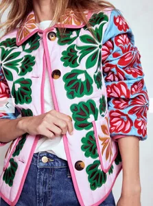 Close-up view of women's street trend quilted jacket with colorful floral embroidery