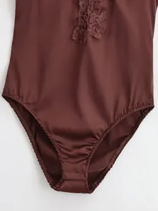 Close-up of a coffee brown satin bodysuit featuring intricate floral lace details and snap closure