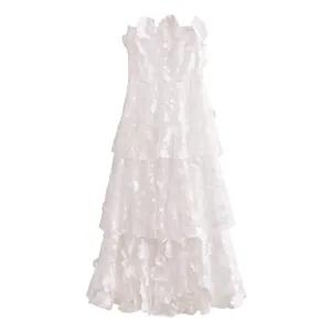 Detailed view of white strapless maxi dress featuring 3D floral lace and tiered ruffles